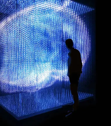 Visitor standing inside a room-scale 3D LED matrix volume