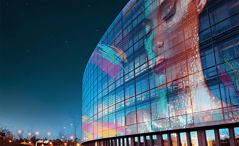 Media facade concept on a curved glass building at night